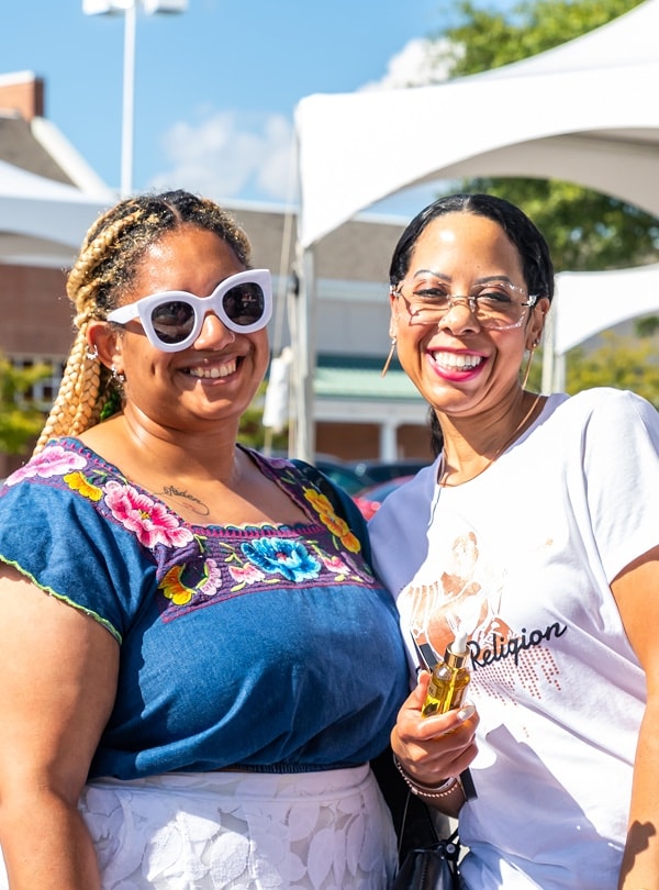 Two women smiling at a community event